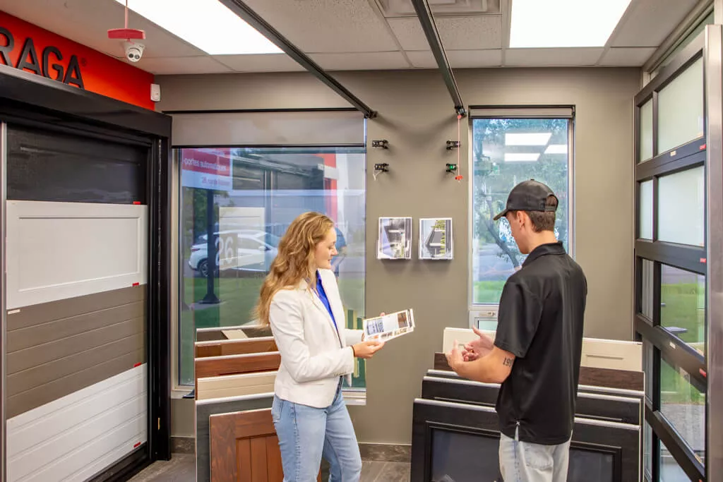 Conseiller de Portes Exitech avec une cliente proposant les multiples options possibles pour une porte de garage résidentielle Garaga dans la salle de montre de Gatineau