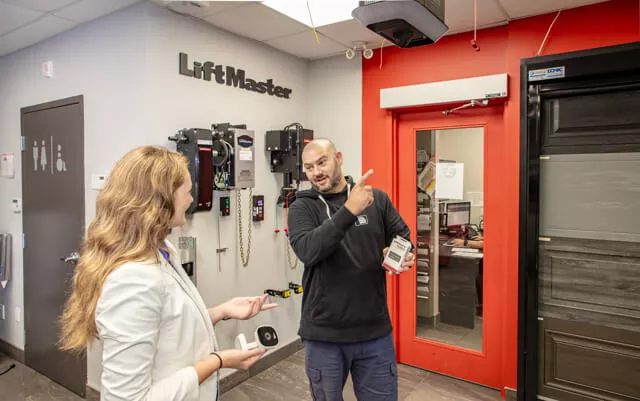 Une cliente obtient des conseils dans la salle de montre de Portes Exitech afin de choisir le meilleur ouvre-porte de garage pour ses besoins